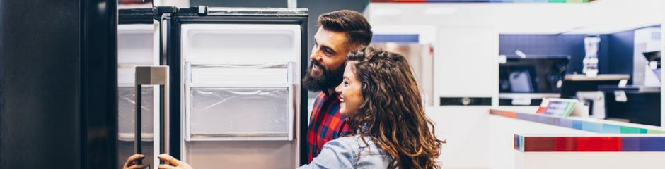 A couple shopping for a new refrigerator in an appliance store