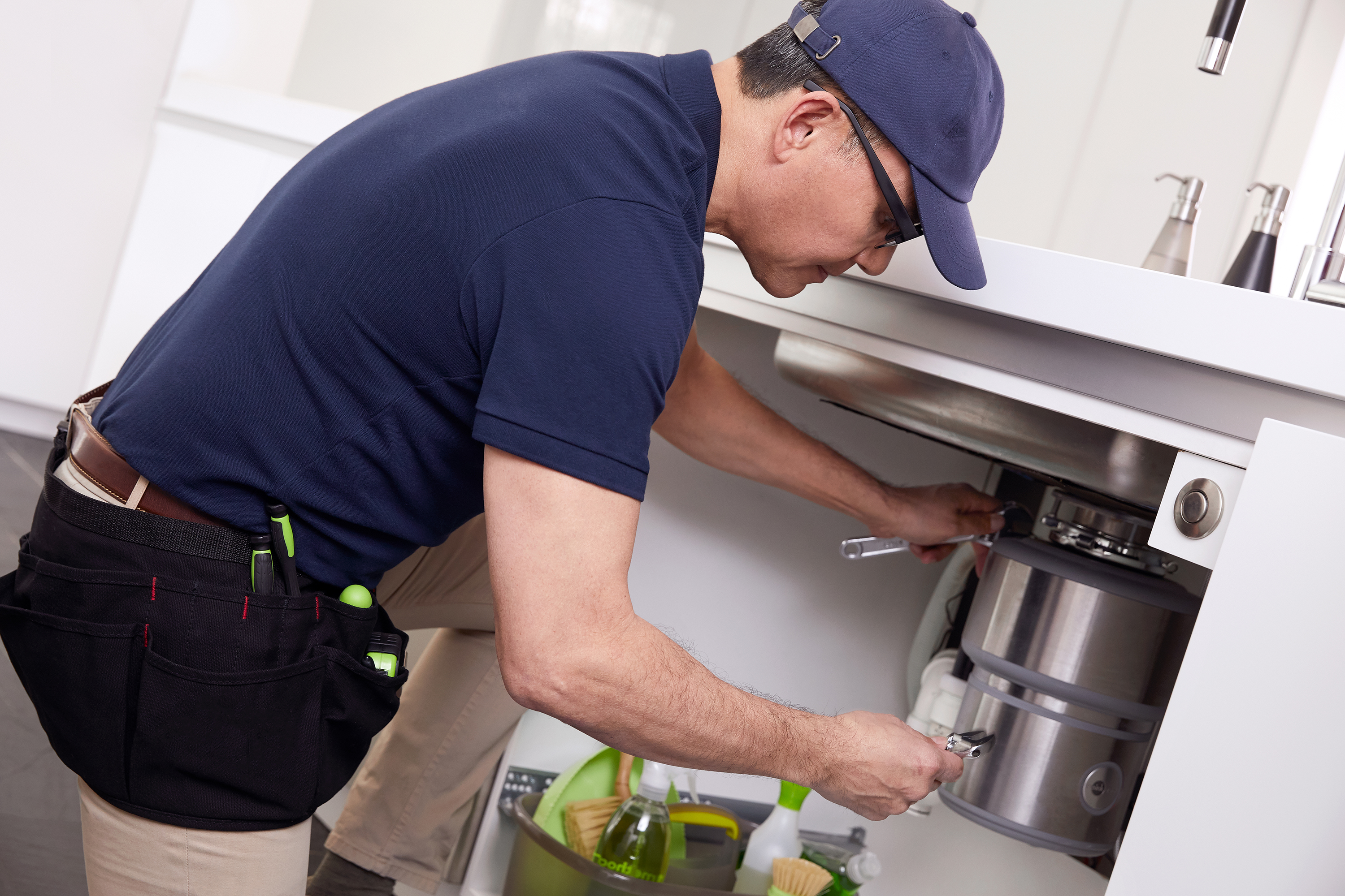 Technician fixing a garbage disposal