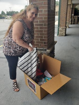 A Cinch volunteer packs a box of school supplies for the Back to School Drive 