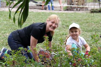 A young girl and Cinch employee gardening during the Homes for Our Troops event