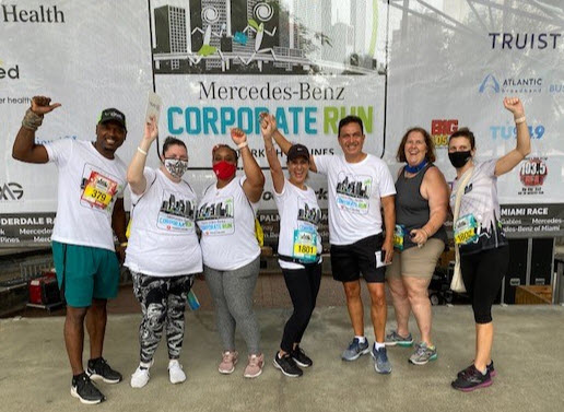 Cinch Home Services employees cheering for their completion of the 2021 Mercedes-Benz Corporate Run