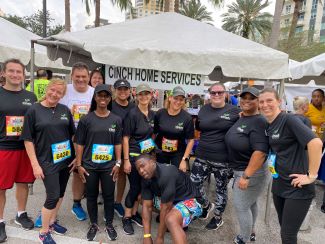 Cinch Home Services employees standing at the Cinch tent and getting ready for the 2022 Mercedes-Benz Corporate Run