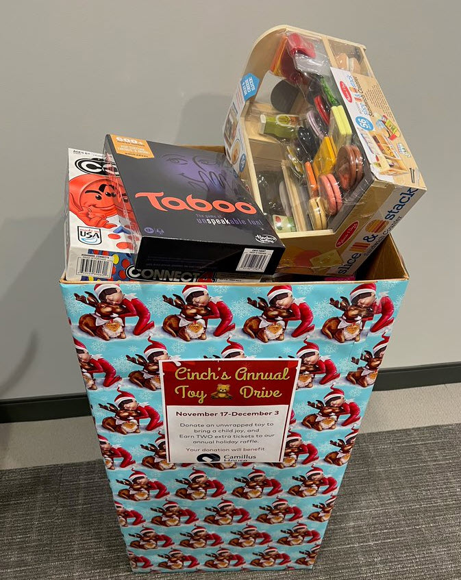 Festive holiday box filled with toys for all ages for Cinch Home Services's Annual Toy Drive to benefit Camillus House