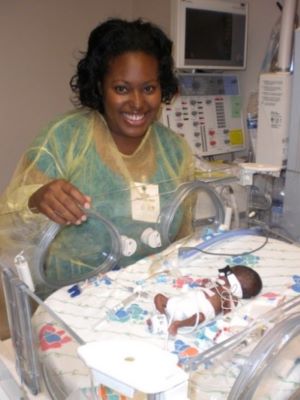 Kelvia standing next to baby Kelyssa at the Broward Health’s Neonatal Intensive Care Unit