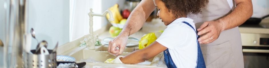 A father helping his daughter do the dishes