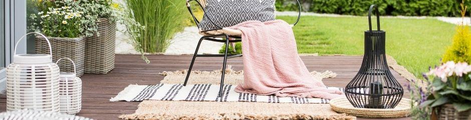 <p>Backyard deck with vases, baskets and area rugs. <\/p>