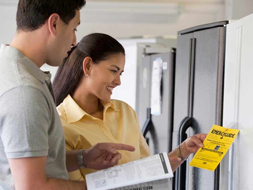Young couple reading appliance energy guide