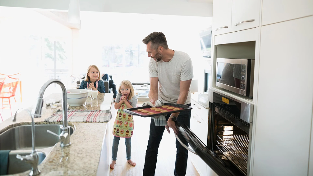 Father with daughters baking in a kitchen