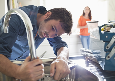 Plumber fixing a sink faucet