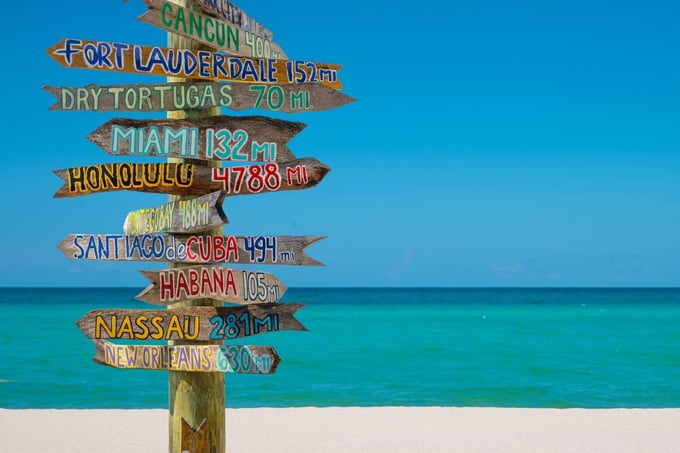 Home warranty in Florida - Signpost of various locations on a beach