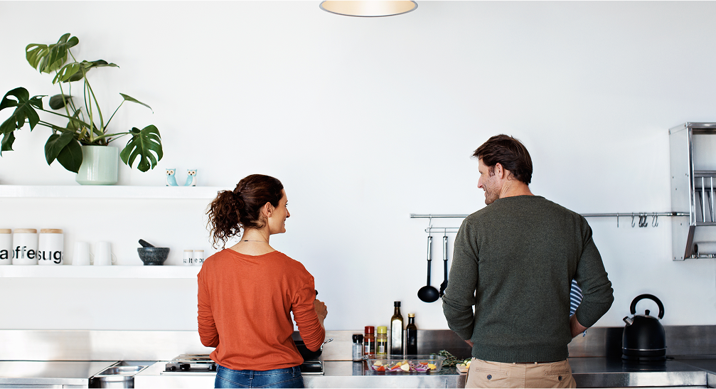 Man and woman talking to each other in a kitchen